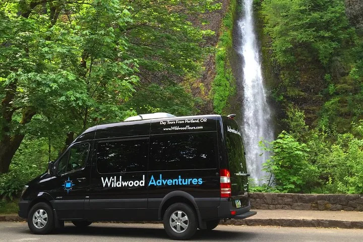 Ein Tourvan von Wildwood Adventures vor einem Wasserfall